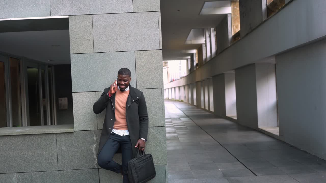 Man in Coat Talking on Phone in Urban Setting