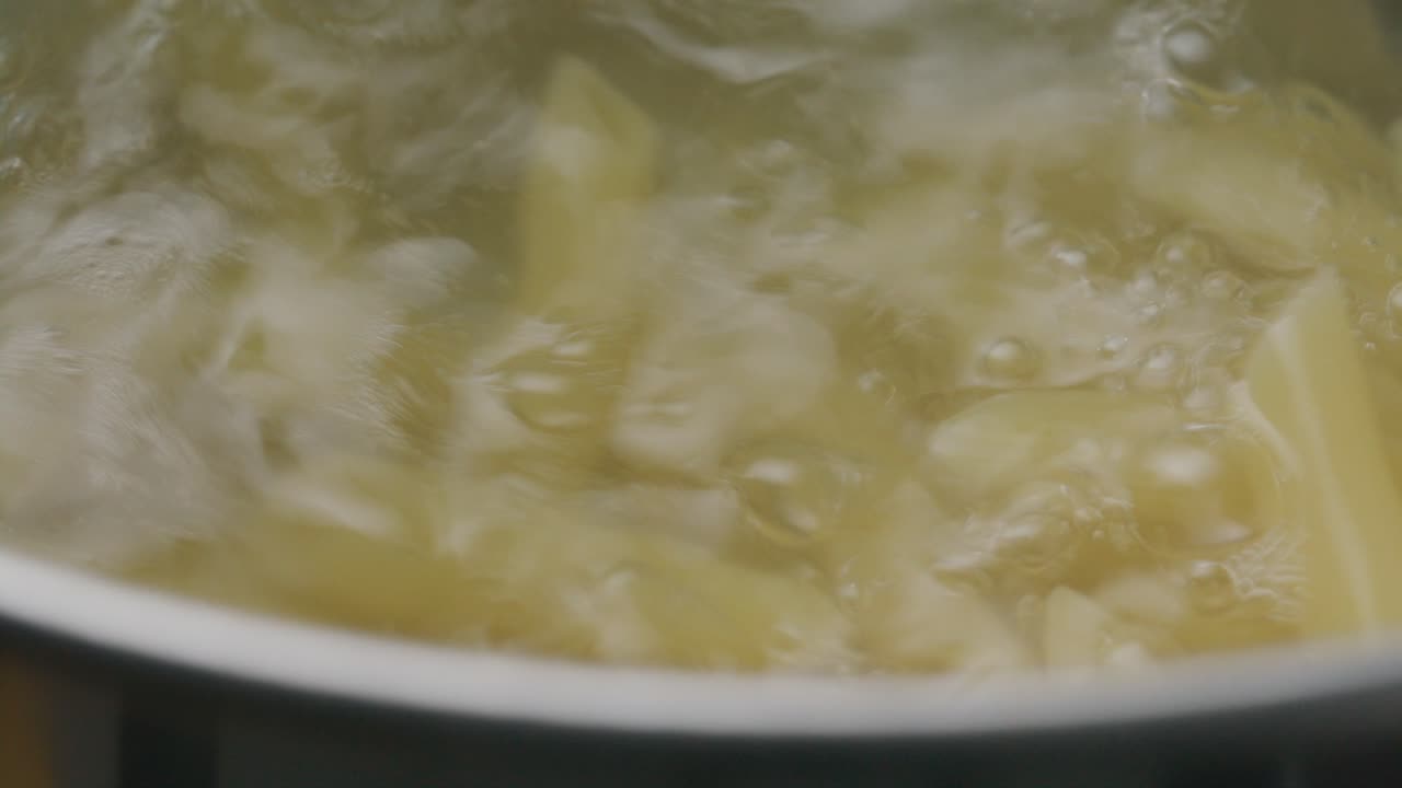 Cottura di penne in una pentola di acqua bollente.