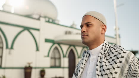 a muslim man in front of a mosque