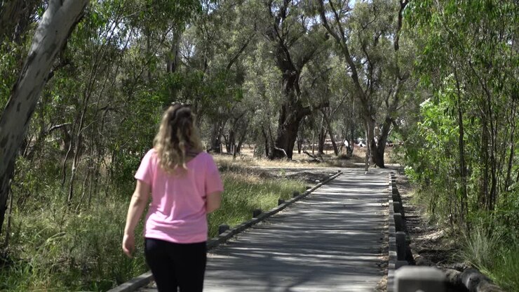 Mulher loira bonita caminhando na natureza de óculos de sol