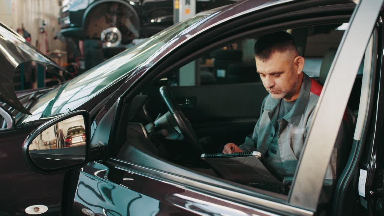 mecánico de automóviles diagnosticando un coche en un taller de reparación
