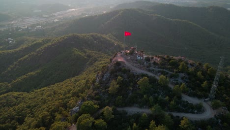 Aerial-4K-drone-footage-of-a-hill-with-the-Turkey-flag-waving-about-the-city-of
Kemer