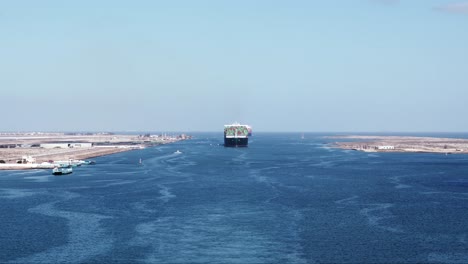 wide shot of a large container vessel entering suez canal in port said