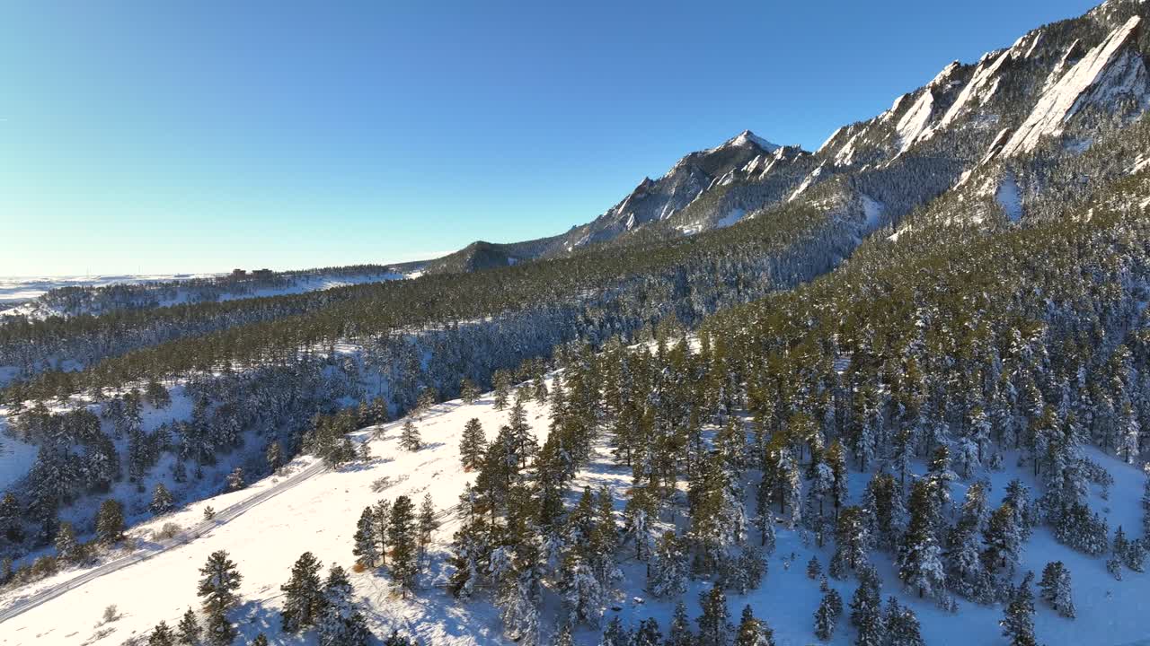 panorámica aérea de drones del paisaje invernal nevado con árboles y montañas flatiron en boulder, colorado, ee.uu.