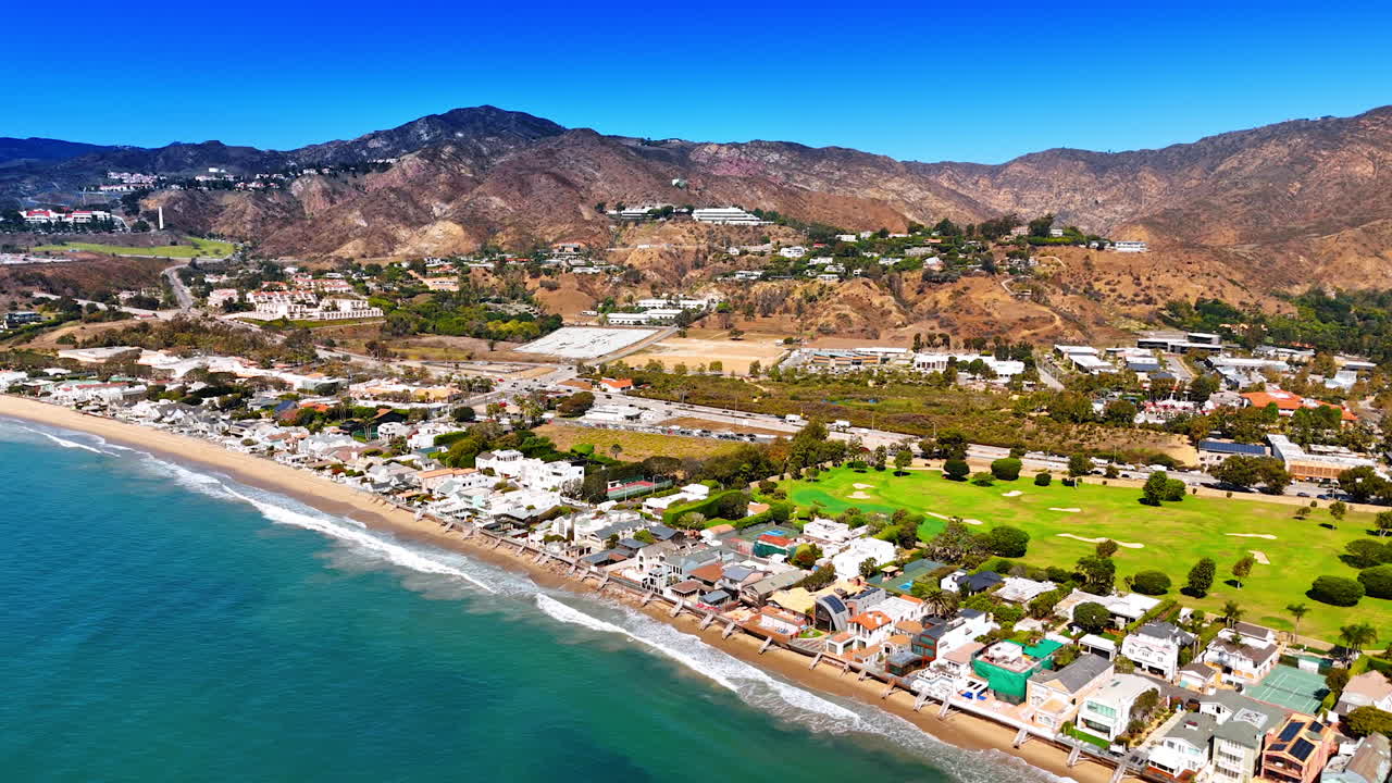 Stunning panorama of sunny Malibu, Los Angeles County, California, USA. Waves roll to the empty beach. Aerial view