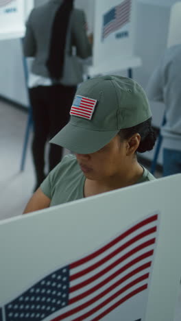 female american soldier comes to vote in booth in polling station office. national election day in the united states. political races of us presidential candidates. concept of civic duty. dolly shot.