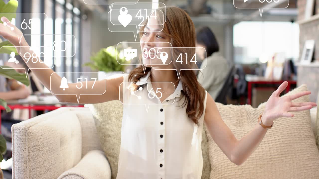 Woman sitting sofa in office speaking starting social icons moving across face or torso boosting rea