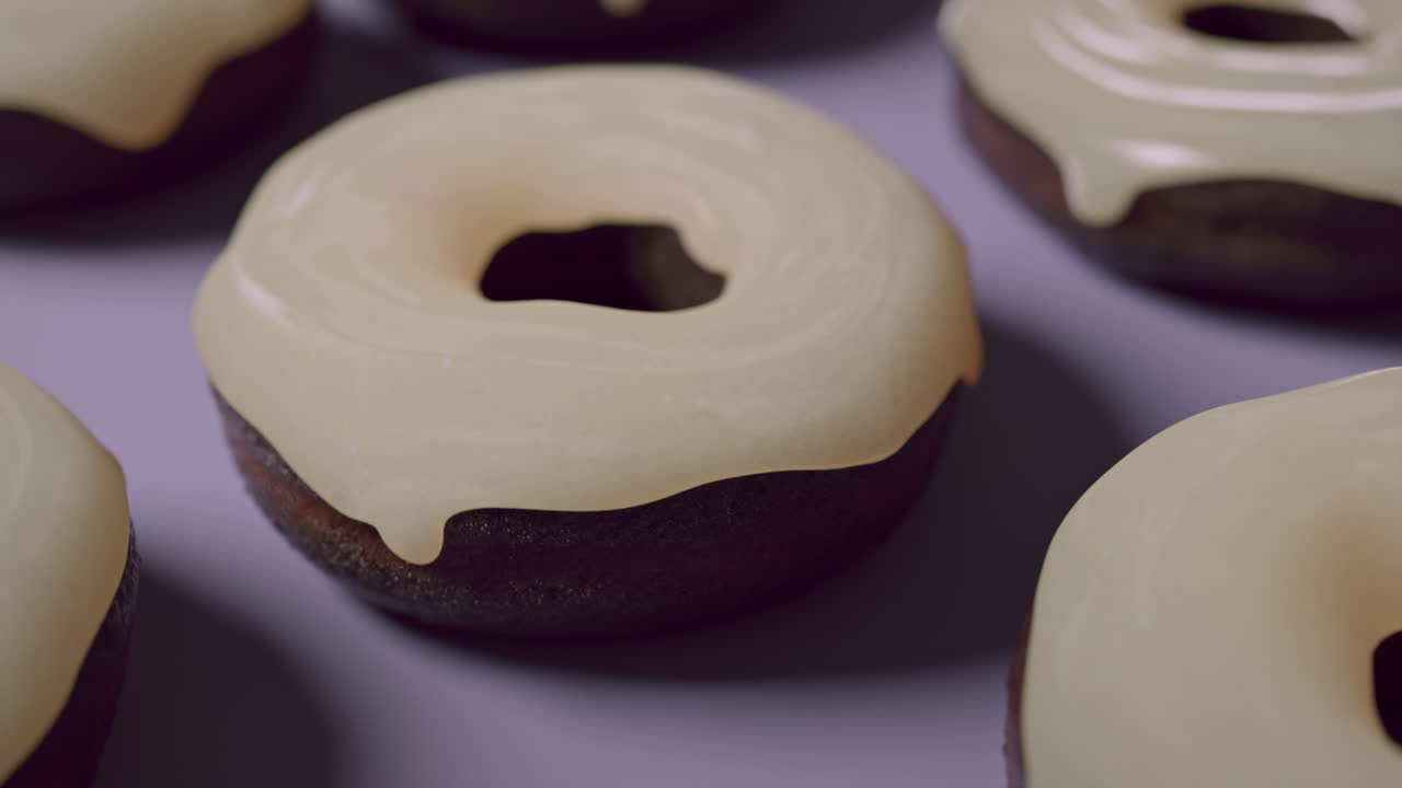 White glaze donuts on a light violet background
