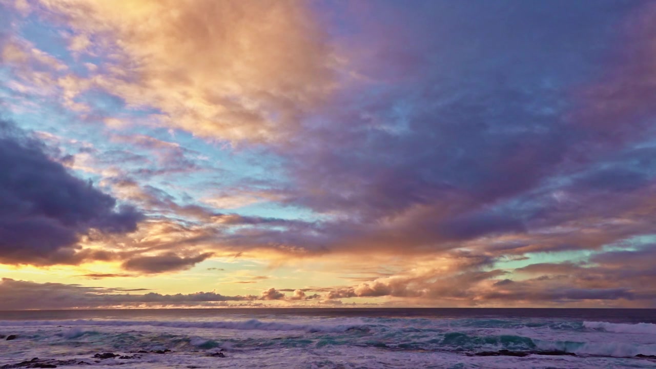 Ampia vista di nuvole drammatiche al tramonto sopra il Mar Tirreno, sulla Costiera Amalfitana in Italia. Cieli arancioni e viola risplendono sopra le onde del mare.