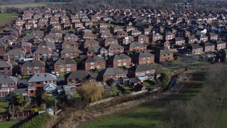 typical suburban village anglesey residential neighbourhood property rooftops aerial view low dolly right