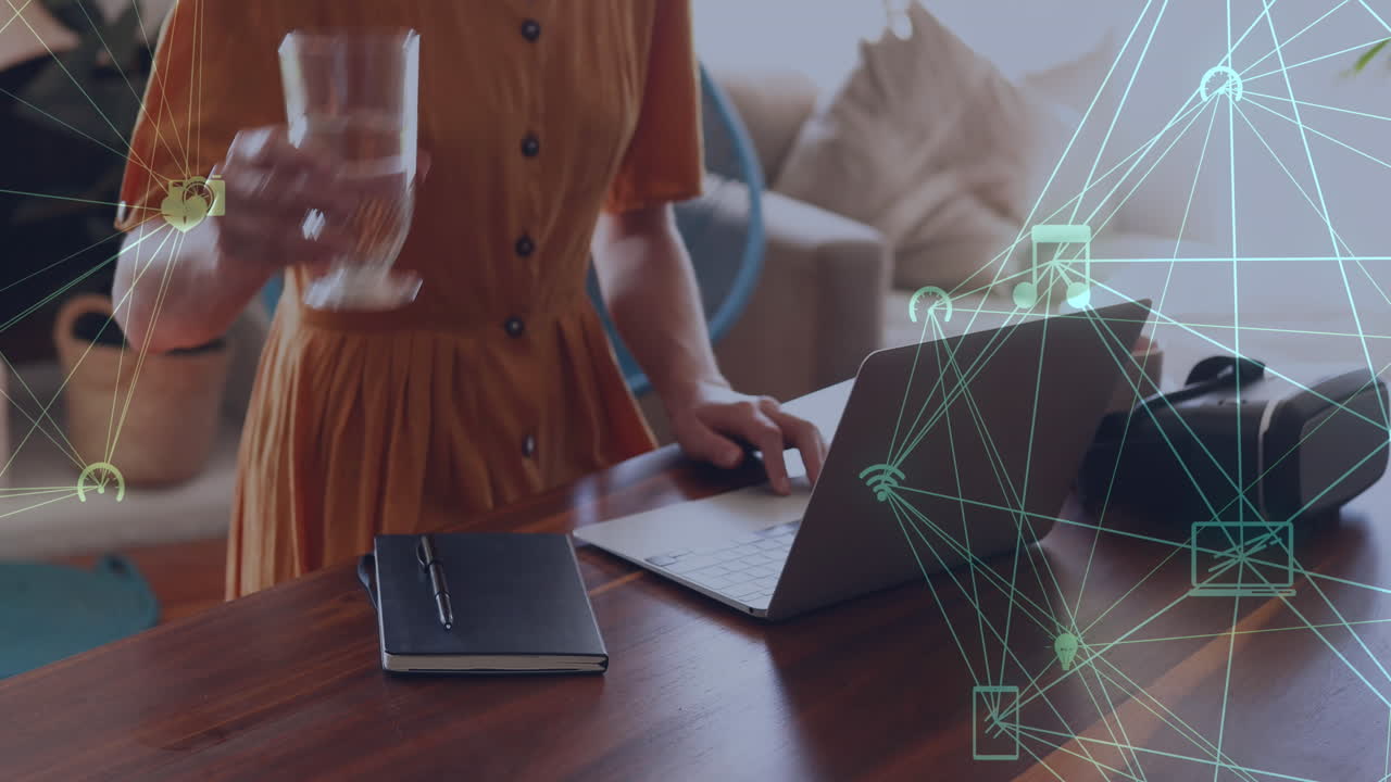 animación de una red de conexiones con iconos de los medios sobre una mujer caucásica usando una computadora portátil