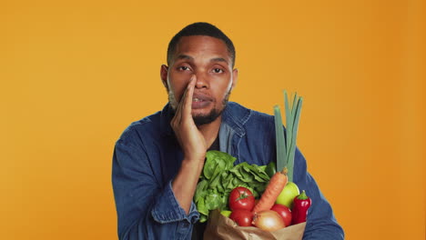 young adult whispering his secrets about buying locally grown bio produce