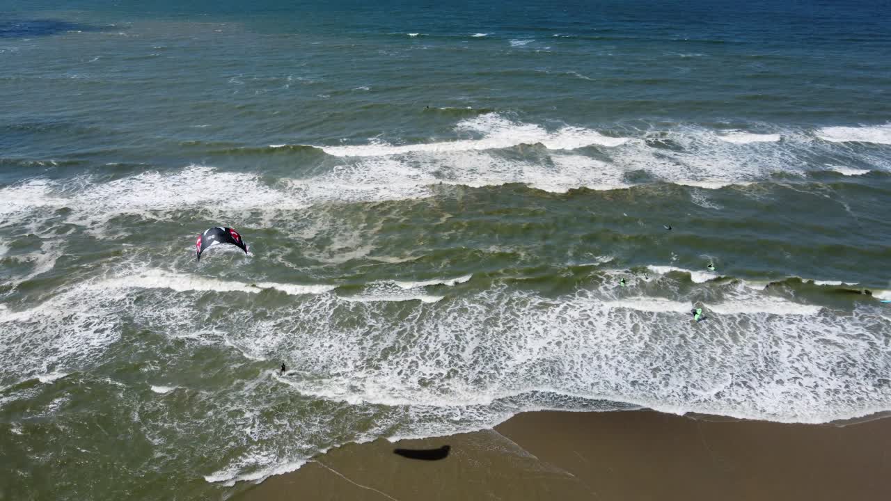 un kitesurfista siendo arrastrado a lo largo de la superficie del mar por paracaídas