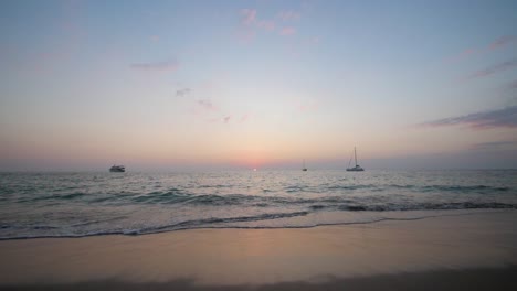 Sun-setting-in-the-horizon-at-beach-in-Koh-Lanta,-Thailand---wide-static-ultra-slow-motion-shot