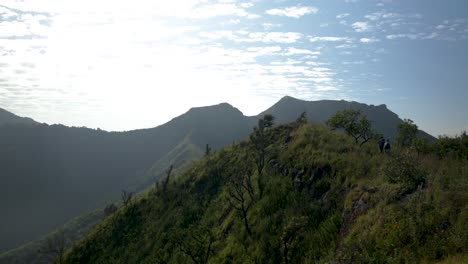 un hombre occidental caminando a lo largo de una línea de cresta montañosa épica en áfrica oriental