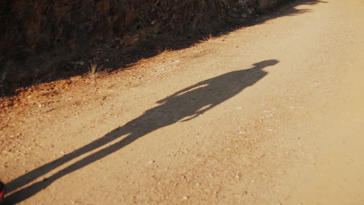 Ombra di una persona su un sentiero sterrato