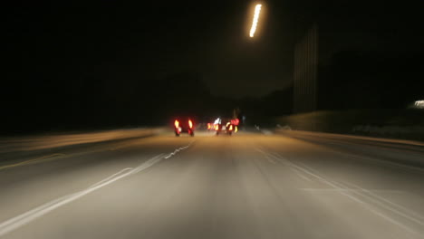 a car speeds along a highway at night in time lapse