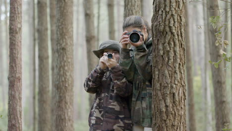 Mujer-Joven-Y-Niño-Parados-Entre-árboles-En-El-Bosque,-Explorando-La-Vida-Silvestre-Con-Monocular-Y-Cámara-Y-Tomando-Fotos