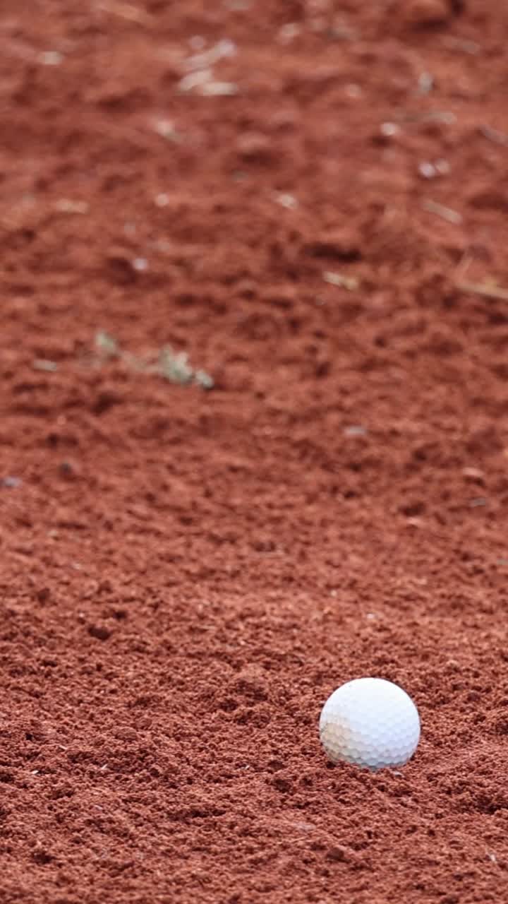 Mazza da golf che colpisce la palla in un bunker di sabbia