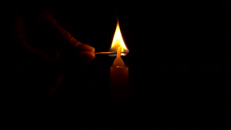 una sola vela blanca ardiendo. bucle para su uso como fondo o ilustración de recuerdo o celebración. el viento trata de apagar la llama, pero se recupera cada vez. la llama eterna.