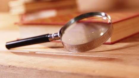 Magnifying-glass-with-a-book-on-desk