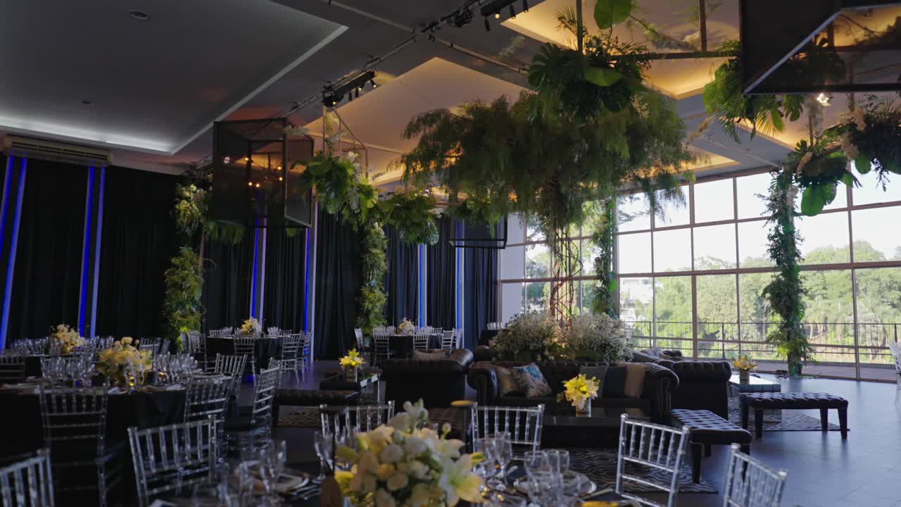 Elegante salón interior para eventos con mesas y flores decoradas para bodas con iluminación ambiental
