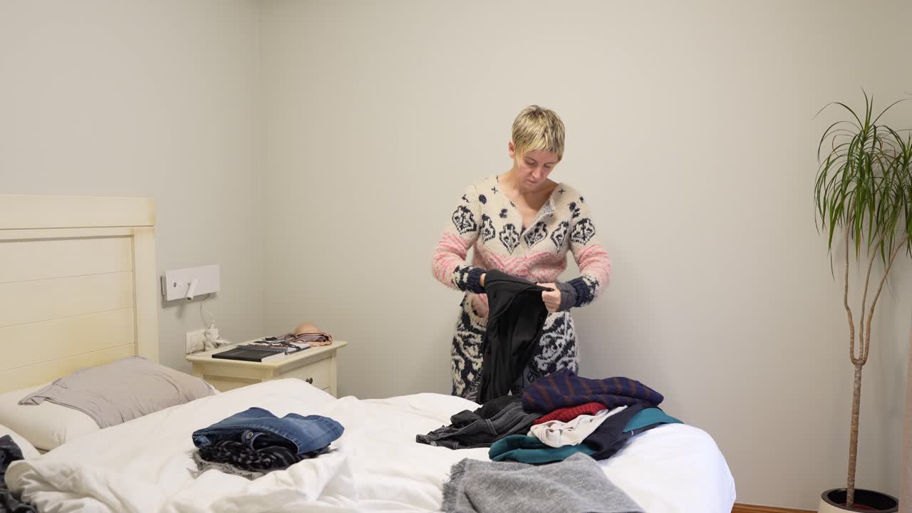 Woman folding clothes in a bedroom
