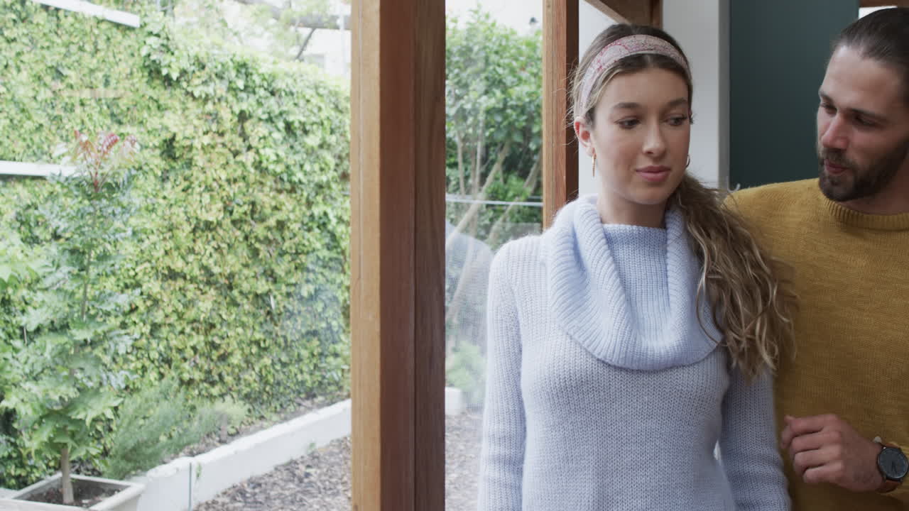 다양한 행복한 커플이 집에서 창문을 통해 포옹하고, 느린 동작으로, 공간을 복사합니다.