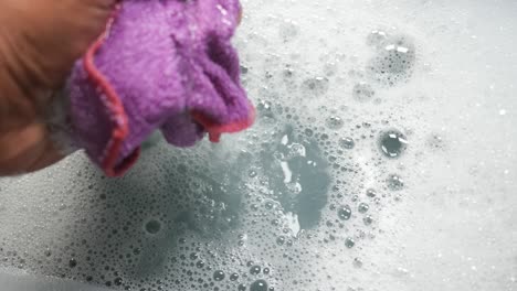 washing a purple cloth in soapy water