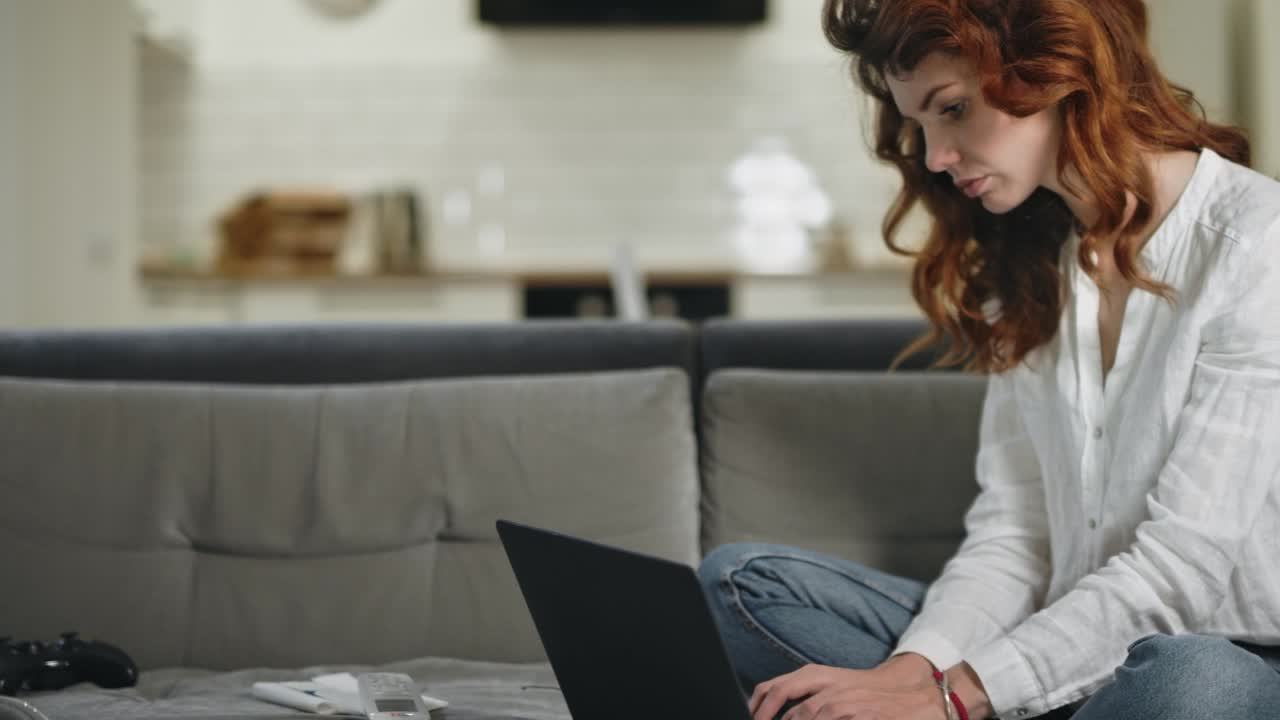 mujer de negocios seria trabajando en una computadora portátil en un lugar de trabajo remoto.