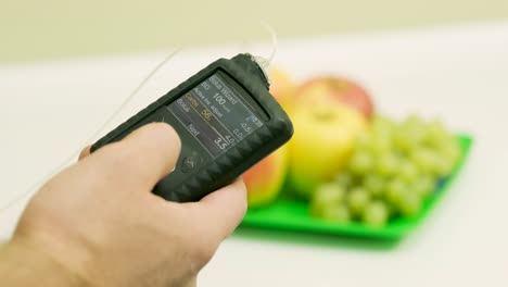 diabetic man with an insulin pump connected in his abdomen and holding the insulin pump at his hands. diabetes concept.