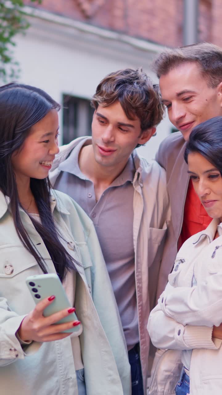 Gruppo eterogeneo di giovani adulti che condividono contenuti su uno smartphone