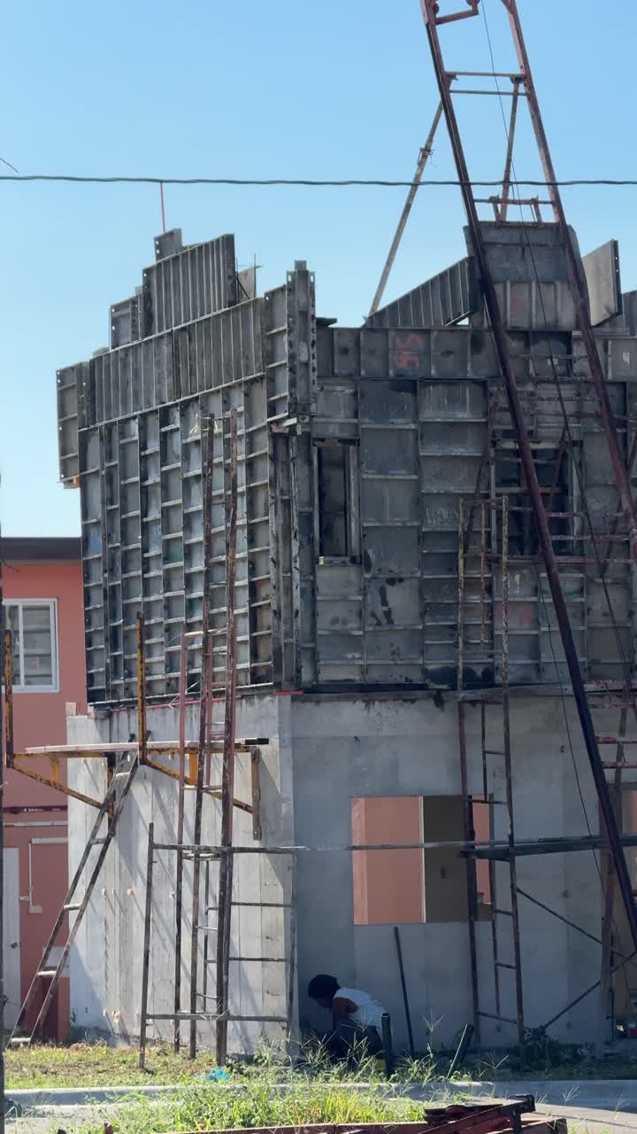 Toma a nivel del suelo de un hombre trabajando en construcción en un proyecto de casa residencial en Camella Homes Alfonso Cavite, Filipinas.