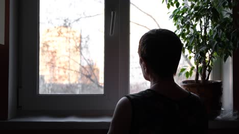 mujer mirando por la ventana