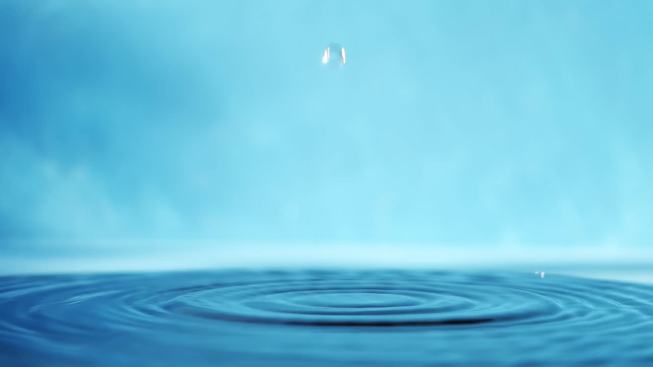파란색 배경에 떨어지는 물방울과 함께 물 표면의 느린 모션 4k 비디오.