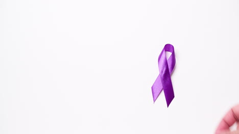 Detail-of-a-male-hand-holding-a-light-purple-ribbon-on-a-white-background