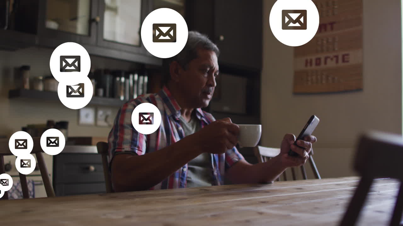 múltiples iconos de mensajes flotando contra un anciano que usa un teléfono inteligente en casa