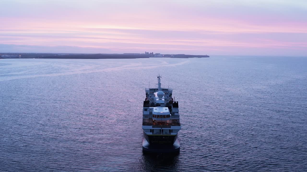 nubes coloridas al atardecer en islandia con crucero turístico anclado en aguas tranquilas
