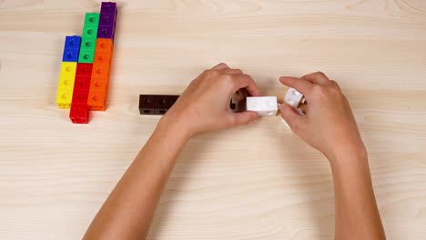 hands assembling cubes on a wooden table