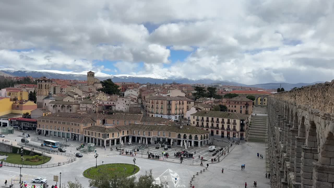 Panoramic Segovia view from city walls with aqueduct and mountains in background.