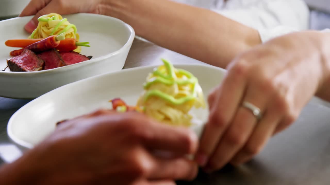 equipo de chefs sosteniendo platos de comida en la cocina comercial