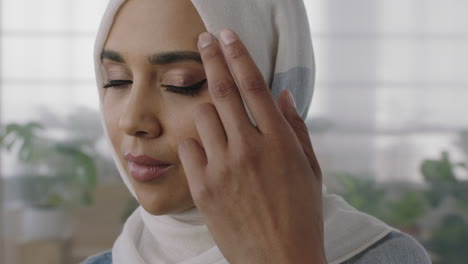 close up portrait of young muslim business woman turns head looking at camera confident wearing traditional hajib headscarf in office workspace background