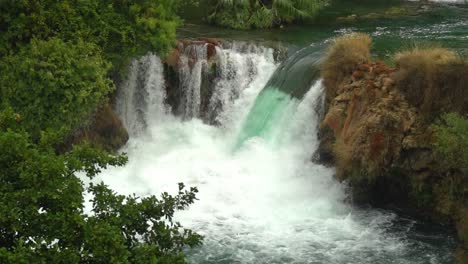 gran cascada que fluye de un estanque a otro estanque azul en el parque nacional krka en croacia a ¼ de velocidad