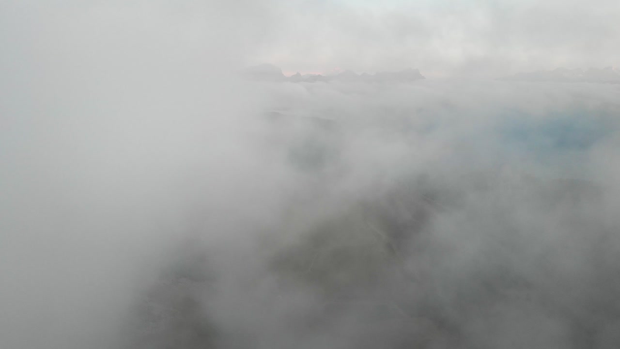 스위스 알프스 산맥에서 다채로운 가을 해가 지는 동안 다양한 산꼭대기가 보이거나 보이지 않는 스위스 바우드의 레이신 (leysin) 위의 구름을 통해 공중 비행