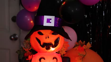 Bunte-Halloween-Party-Mit-Kürbis-Dekor-Und-Luftballons,-Hexenhut-Im-Vordergrund,-Festliche-Stimmung