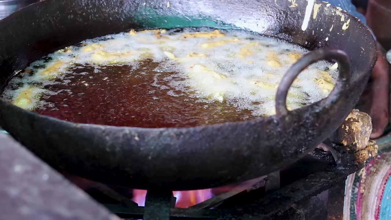 Friturestegning af store chilier i sennepsolie ved en gadebod eller Mirchi Bada, lokale indiske retter på gaden.