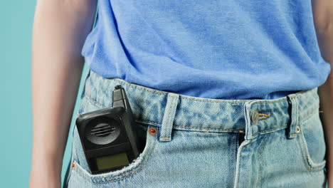 woman with a vintage cell phone in her jeans pocket