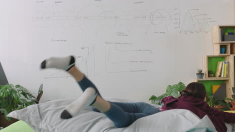 feliz mujer caucásica estudiante saltando en almohadas coloridas relajando mujer descansando disfrutando de la pausa para el almuerzo en un lugar de trabajo de oficina de moda