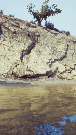 coastal landscape with rocky shore and calm water reflecting a clear sky