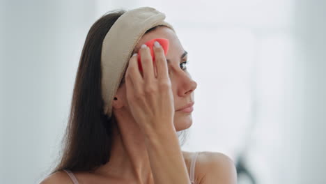 la chica de belleza aplicando la fundación en el interior de cerca. la dama usando la esponja de cosméticos